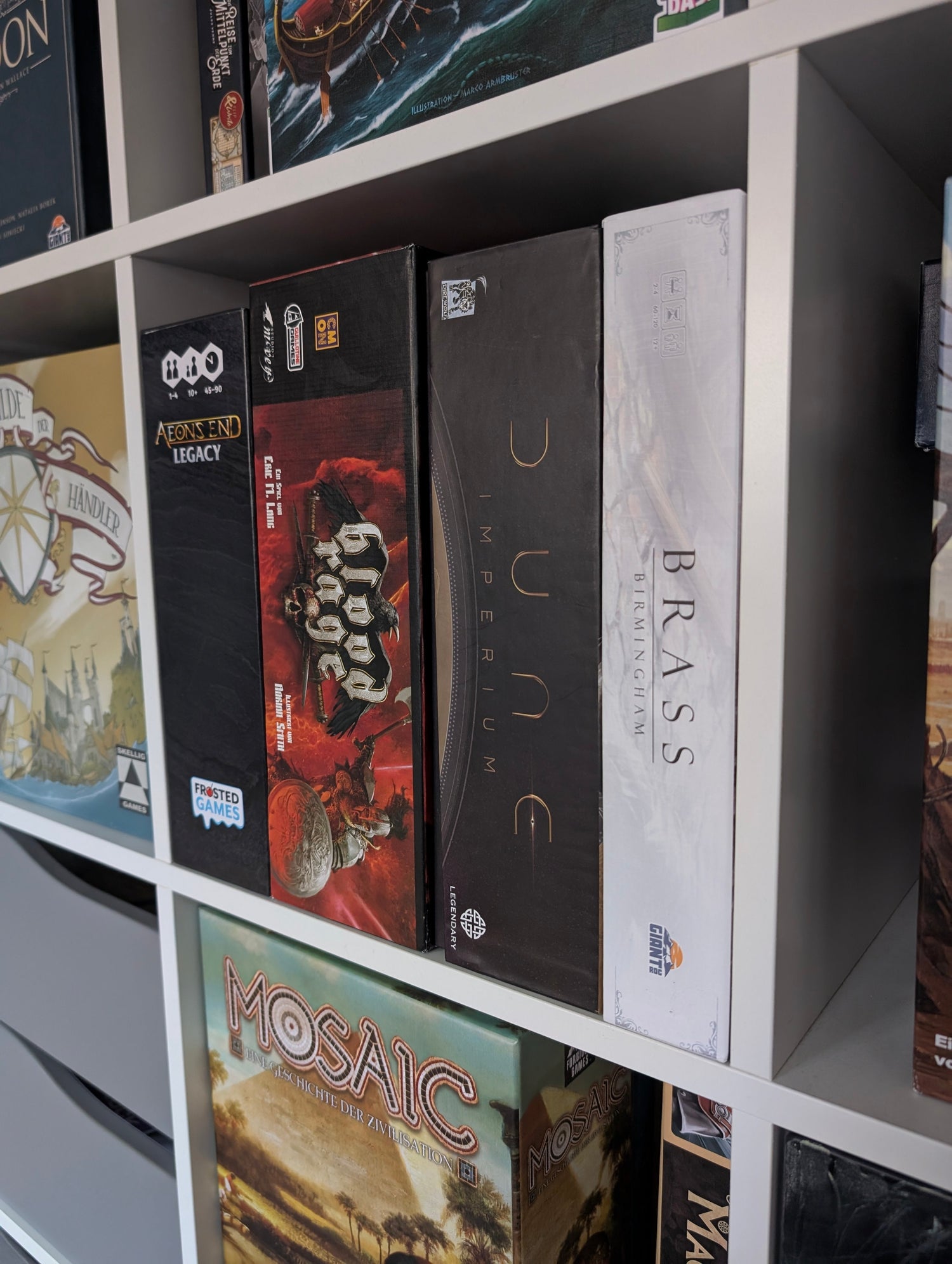 Es werden mehrere Kenner und Experten Spiele in einem Brettspielregal gezeigt.