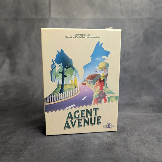 Agent Avenue von Nerdlab ist ein Bluffspiel in einer Schachtel mit dem Titelbild eines Fuchses im Trenchcoat, mit Häusern entlang einer gebogenen Straße, Bäumen und einem weißen Lattenzaun im Hintergrund.
