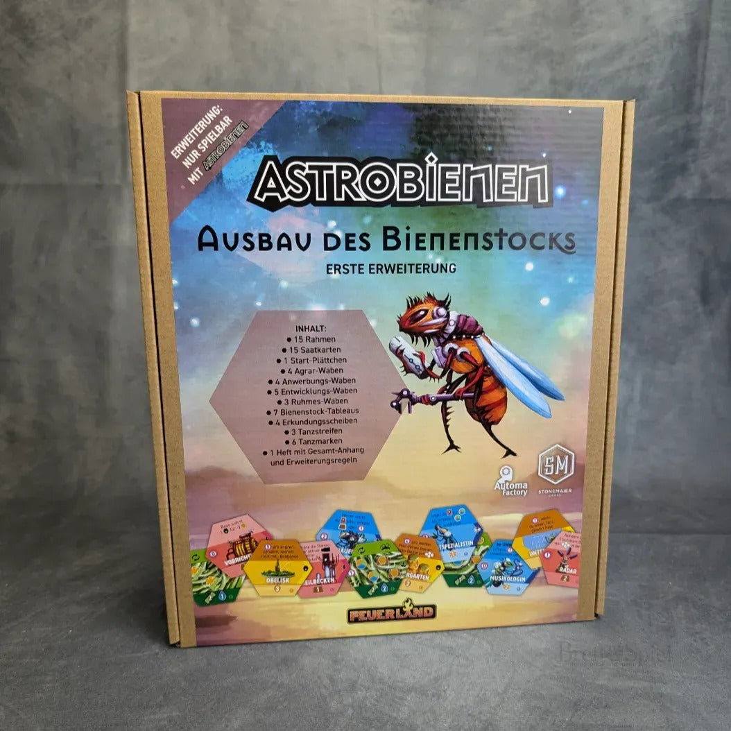 Die Schachtel von Astrobienen - Ausbau des Bienenstocks von Feuerland Spiele zeigt ein lebhaftes Wabenmuster, eine technische Cartoon-Biene und einen deutschen Text, der die Funktionen der Erweiterung beschreibt.
