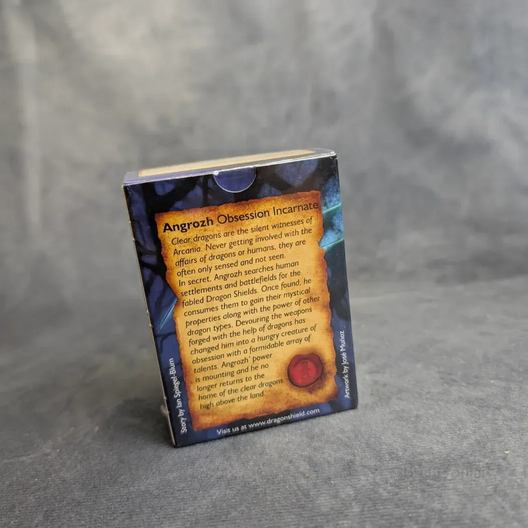 Ein Brett&Spiel Dragon Shield: Matte - Clear (100) Kartenschachtel steht auf einer grauen Oberfläche, auf deren Rückseite ein Text über den Einfluss der Drachen auf die Menschen steht - ideal für Fans von Dragon Shield Hüllen und Sammelkarten Schutz.