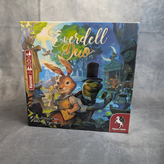Das Schachtelcover von Everdell Duo von Pegasus Spiele zeigt ein Kaninchen in einer Weste und einen Frosch mit Zylinder inmitten eines skurrilen Waldes und weist damit auf das fesselnde Spielgeschehen und die bezaubernde Welt dieses fesselnden Brettspiels hin.