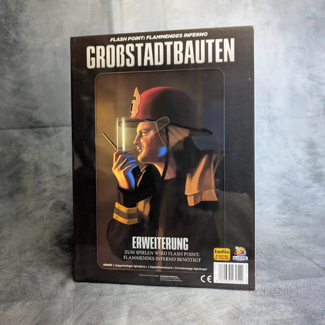 Das Bild zeigt die Heidelbär Games Flash Point: Großstadtbauten Erweiterung für Flash Point: Fire Rescue, das einen Feuerwehrmann im Profil mit einem Funkgerät vor einer Stadtlandschaft und Feuerreflexionen auf der Schachtel zeigt.