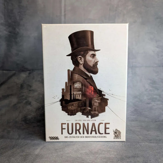 Die Schachtel für Furnace + Erweiterung von Kobold Spiele zeigt einen Mann mit Zylinder und einer Fabrik im Profil, in neutralem Grau gehalten. Untertitel: Das Zeitalter der Industrialisierung. Ein spannendes Engine-Building-Spiel mit Auktionsmechanismus.