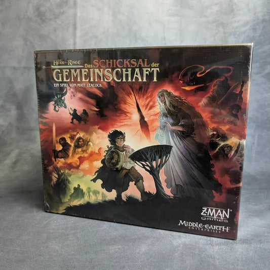 Die Schachtel für Der Herr der Ringe: Das Schicksal der Gemeinschaft von Z-Man Games zeigt Herr der Ringe-Figuren, Feuer, Fantasy-Kunst, deutsche Texte und Logos - perfekt für Fans des kooperativen Brettspiels.