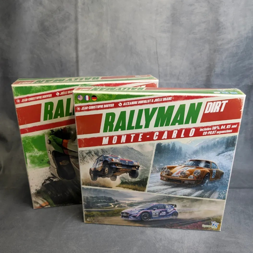 Die Rallyman DIRT + Monte-Carlo Erweiterung von JoeKas World GmbH sind vor einem grauen Hintergrund abgebildet, mit Boxart, die Rallyeautos auf unbefestigten Straßen zeigt - ideal für Fans spannender strategischer Würfel-Rennspiele.
