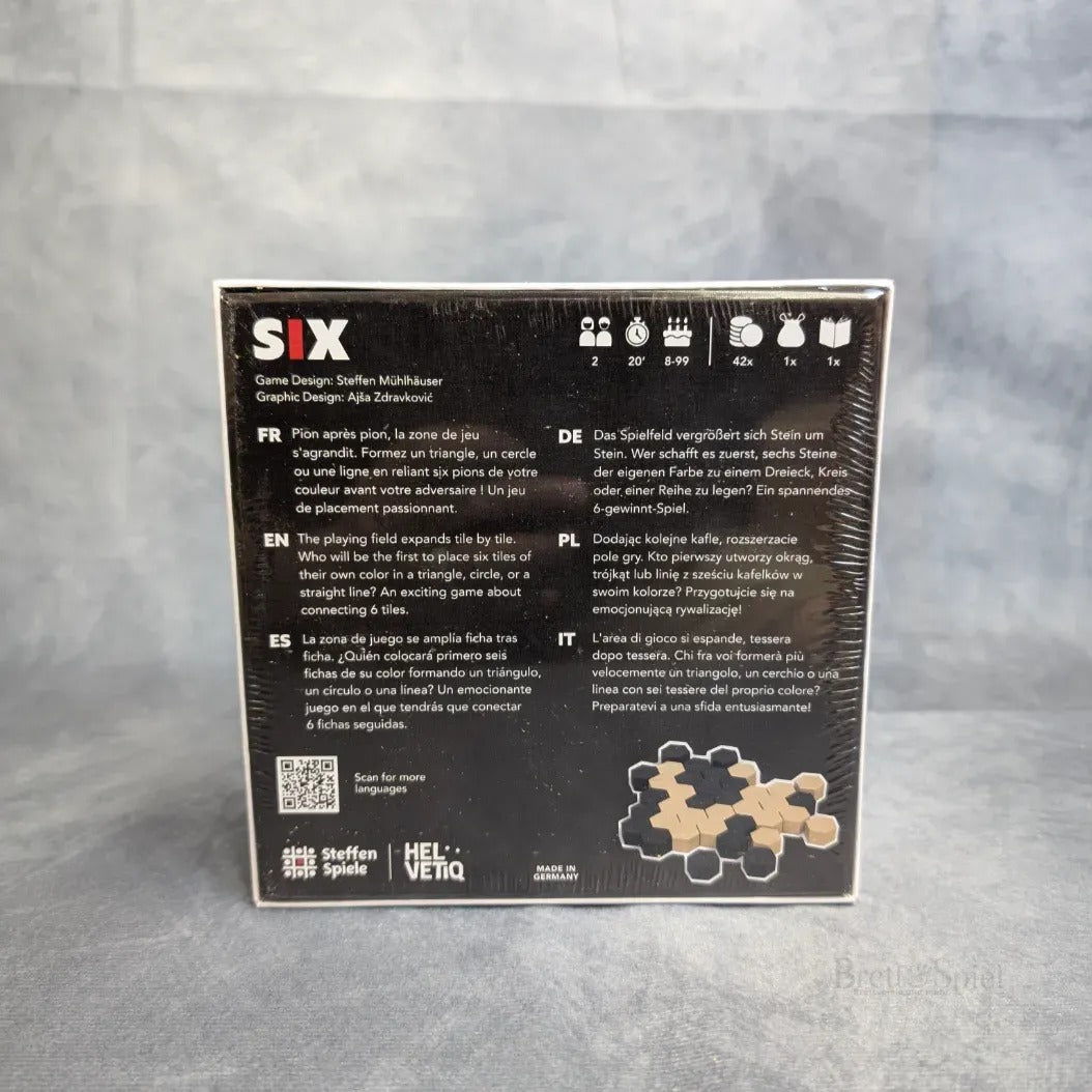 Auf der Rückseite der Six-Brettspielschachtel von Steffen Spiele finden sich mehrsprachige Beschreibungen, Spielsymbole und ein Foto der Holzsteine. Dieses Strategiespiel fordert die Spieler heraus, Steine miteinander zu verbinden und wird eingeschweißt auf grauem Hintergrund geliefert.