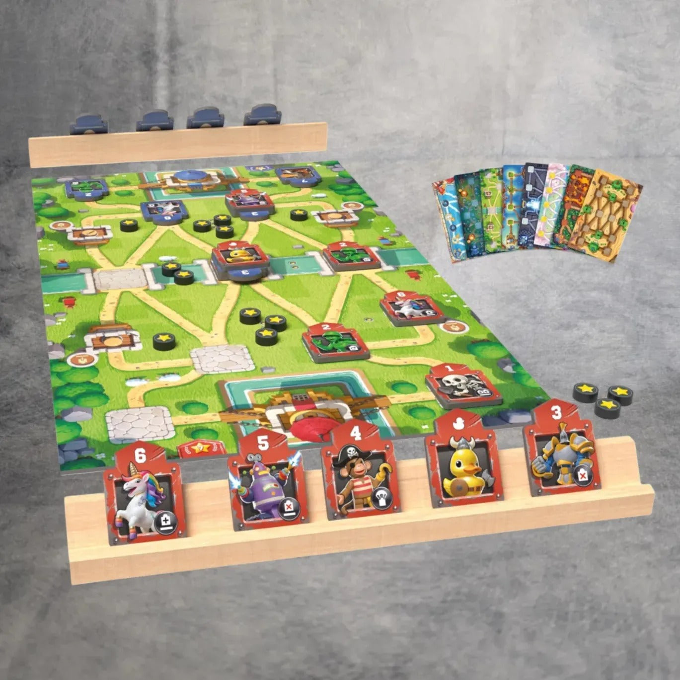 Ein leuchtend grünes Toy Battle-Spielbrett von Asmodee ist mit Pfaden, Charakterkarten, Spielsteinen und illustrierten Kartendecks ausgestattet - perfekt für Fans dieses farbenfrohen Strategiespiels.