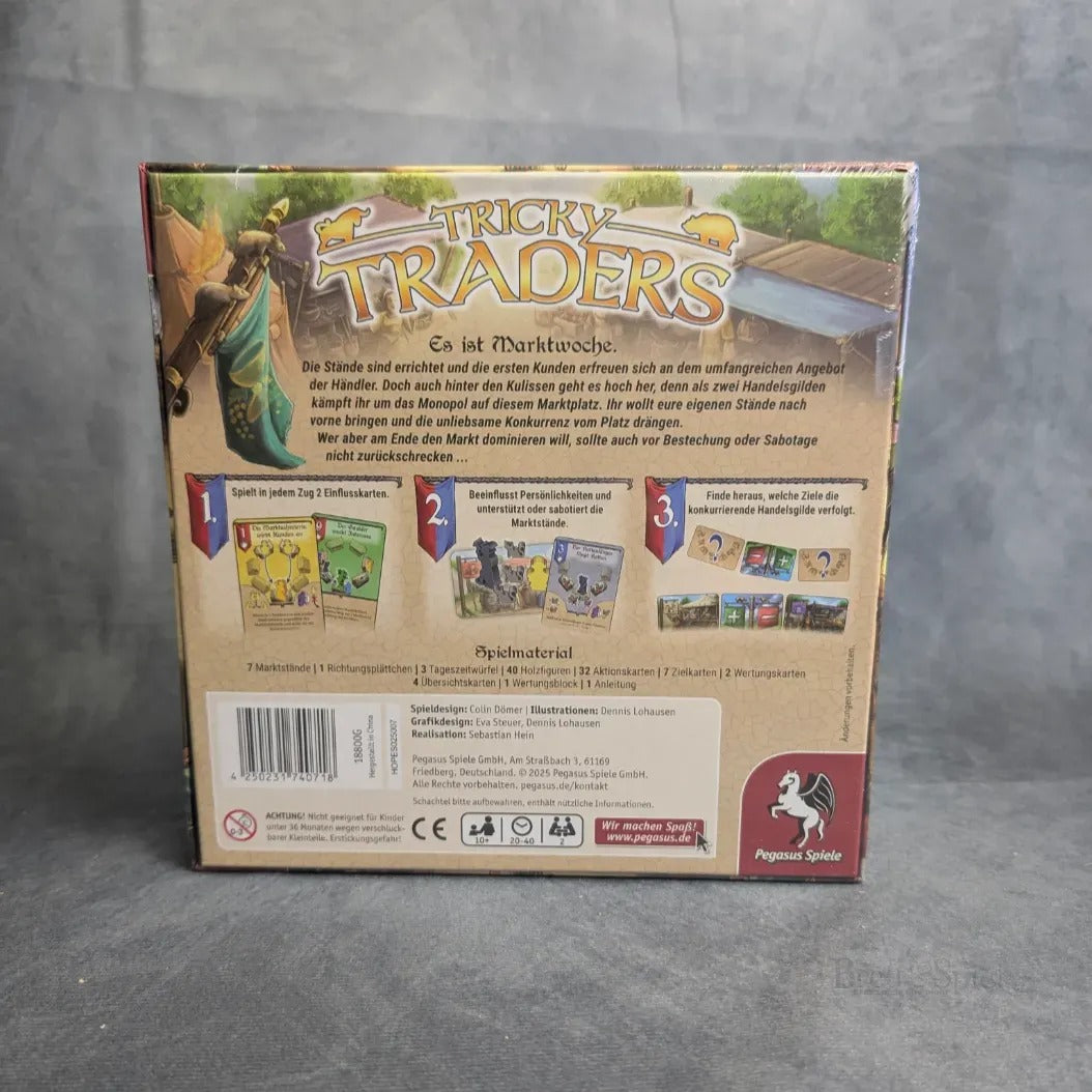 Die Abbildung zeigt die Rückseite der Tricky Traders Schachtel von Pegasus Spiele, mit deutscher Spielanleitung, Handelsgilden, Kartenabbildungen, Komponentenabbildungen und Logos. Die Schachtel steht auf einer grauen, strukturierten Oberfläche.