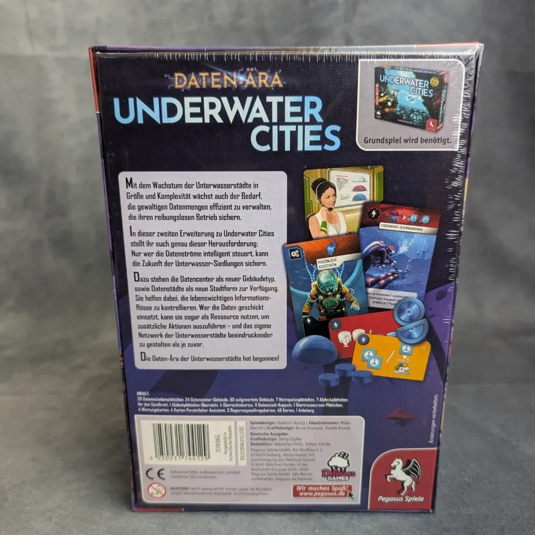Die eingeschweißte Verpackung von Underwater Cities: Daten-Ära (Erweiterung) von Pegasus Spiele steht vor einem grauen Hintergrund und zeigt Box Art, Komponenten, eine kurze deutsche Beschreibung und Verlagslogos.