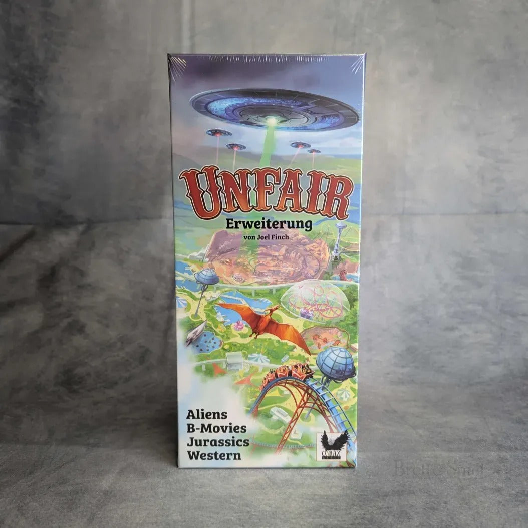 Box von "Unfair - Fiese Freizeitparks ABJW - Erweiterung" von Corax Games, mit lebendiger Kunst von Aliens, UFOs, Dinosauriern und Westernszenen; enthält neue Themendecks: Aliens, B-Movies, Jurassics & Western fürs Aufbauspiel.