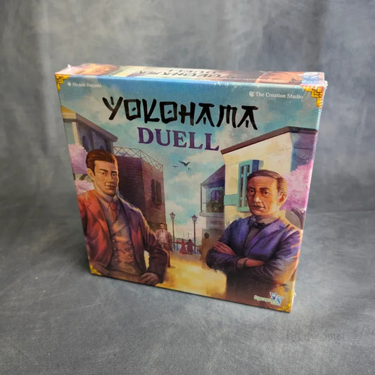 Das Yokohama: Duell von Synapses Games zeigt auf der Schachtel illustrierte Porträts zweier ernster Männer vor einer Straßenszene mit Gebäuden und einem wolkenverhangenen Himmel, alles vor einem grauen Hintergrund.