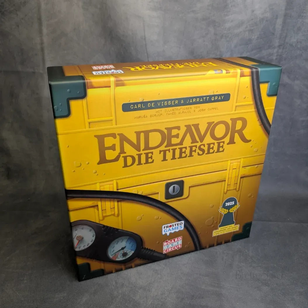 Eine Schachtel von Frosted Games' Endeavor: Die Tiefsee mit einem gelben U-Boot-Design mit Messinstrumenten und Nieten. Die Schachtel zeigt Details zum Spiel, Auszeichnungen wie Kennerspiel des Jahres 2025, alles auf einem grauen, strukturierten Hintergrund.