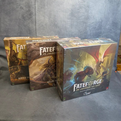 Drei Spielschachteln von Fateforge: Das komplette Kaan-Epos - Grundspiel & Erweiterungen der Squink GmbH stehen aufrecht auf einer grauen Fläche und zeigen Fantasy-Artworks und Szenen aus der kooperativen Brettspielreihe.