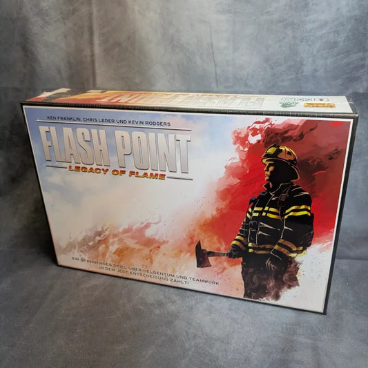 Das Flash Point Legacy: Deutsche Ausgabe von Heidelbär Games zeigt einen Feuerwehrmann mit einer Axt inmitten von Rauch und Flammen, mit den Namen der Schöpfer am oberen Rand der Schachtel.