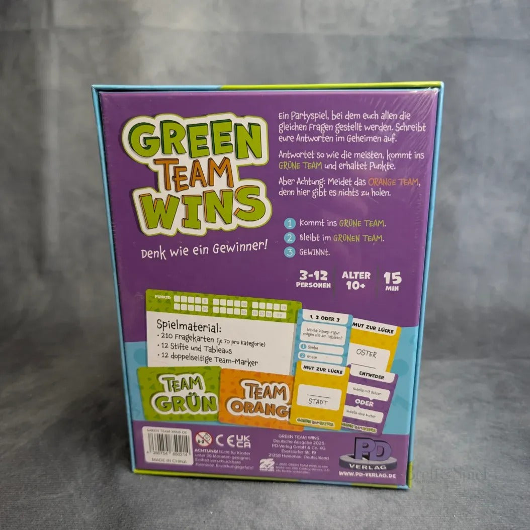 Die Rückseite der Schachtel von Green Teams Win aus dem PD Verlag zeigt die Spielbeschreibung, die Komponenten und die Anforderungen in deutscher Sprache. Das farbenfrohe Design mit grünen, orangefarbenen und lila Akzenten hebt das Spiel als Partyspiel hervor; der Inhalt ist am unteren Rand aufgelistet.