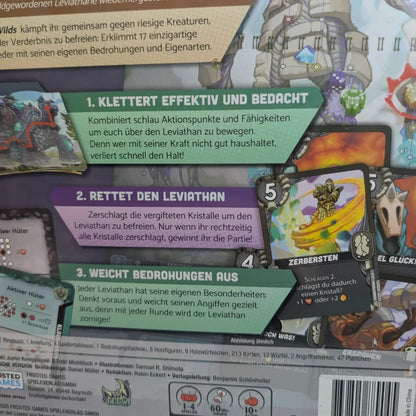Ein Leviathan Wilds Anleitungsblatt von Frosted Games für ein kooperatives Spiel zeigt drei Schritte in grün, blau und gelb. Eine ZERBERSTEN-Karte mit einer grünen Kreatur und 5 ist teilweise abgebildet - ideal für Fans des Kampagnenmodus.