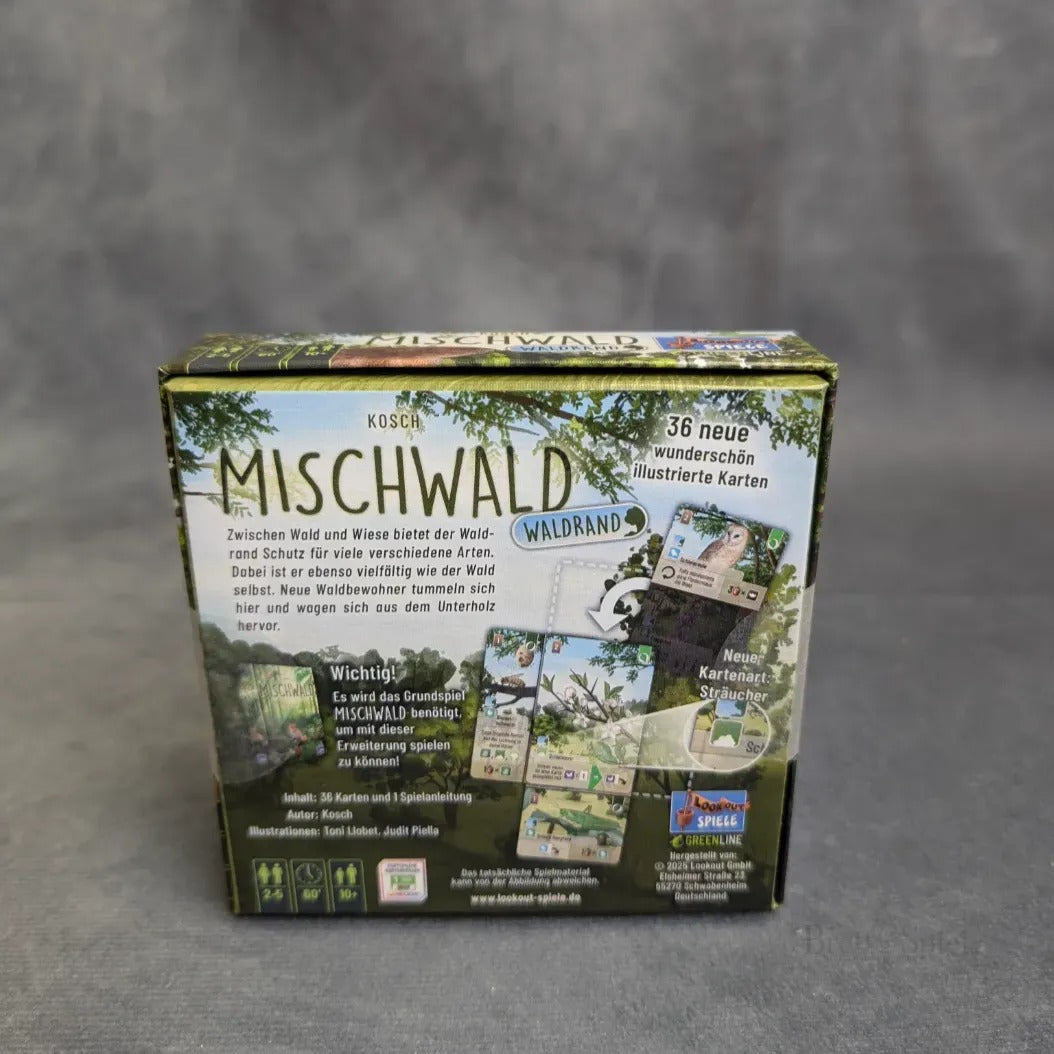 Eine Schachtel von Asmodee's Mischwald - Waldrand ruht auf einer grauen Oberfläche. Die Rückseite zeigt deutschen Text, lebendig illustrierte Karten und Bilder, die die Komponenten und Details des Spiels zeigen.