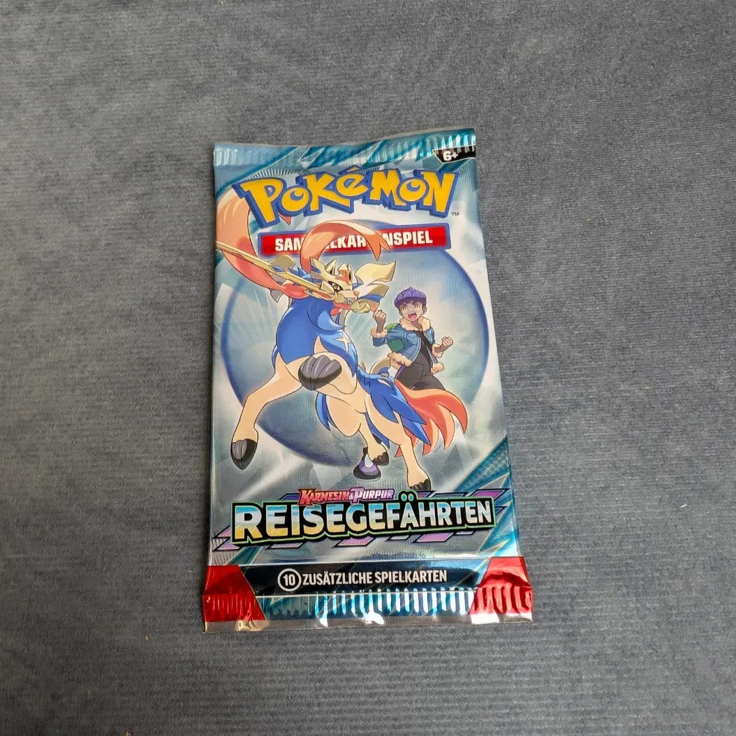 Ein versiegelter Pokèmon PKM KP09 Reisegefährten Booster von Burst Spiele, der auf der Vorderseite zwei Charaktere und ein Pokémon zeigt, wird auf eine graue Fläche gelegt.
