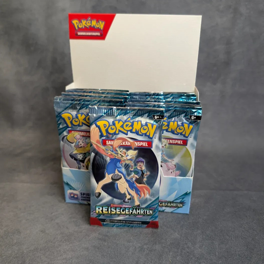 Ein Displaykarton mit Pokèmon PKM KP09 Reisegefährten Booster-Packs von Burst Spiele, mit mehreren ungeöffneten Boostern aufrecht stehend, die jeweils unterschiedliche Pokémon-Designs auf der Verpackung aufweisen.