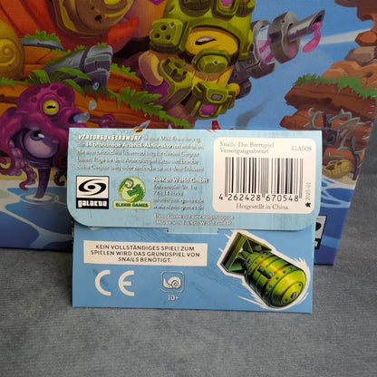 Eine kompakte Snails: Das Brettspiel + Abwurf Erweiterung von JoeKas World GmbH mit der verspielten Grafik einer grünen Rakete und einer Tentakel-Kreatur steht vor der lebendigen Spielschachtel - ideal für Fans von taktischem Miniaturenspiel und Aktions-Programmierung.