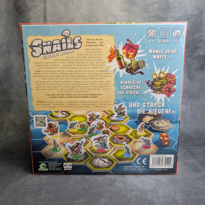 Back of Snails: Das Brettspiel + Abwurf Erweiterung von JoeKas World GmbH zeigt Komponenten, Cartoon-Schnecken, Hex-Plättchen, eine Kanone, deutschen Text, Spielinformationen für 1-6 Spieler (ab 10 Jahren) und einen Aktions-Programmier-Mechanismus.