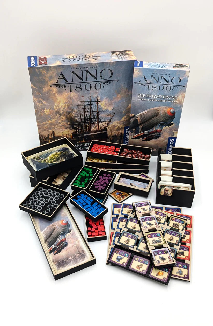 Der Anno 1800 Einsatz von 3D-Inset ordnet Spielkarten, Plättchen und Spielsteine in der Anno 1800 Schachtel, die neben der Anno 1800 Erweiterung ausliegt. Das Schachtelmotiv zeigt ein Schiff und historische Bilder, auf denen bunte Spielsteine verteilt sind.