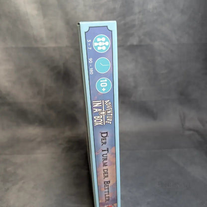 Der Buchrücken der Brettspielbox "Abenteuer in der Box: Sturmfels Akademie - Der Turm der Bettler" von Ulisses Spiele GmbH, ein Mini-RPG für 3-7 Spieler ab 10 Jahren, mit einer Spielzeit von 90-180 Minuten.