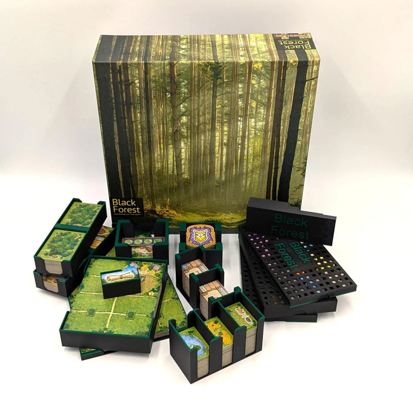 Das Brettspiel Black Forest wird mit seiner Schachtel gezeigt, die eine Waldszene zeigt. Spielfiguren, Karten, Spielsteine und Spielbretter werden mit dem 3D-Inset Black Forest Insert auf einer weißen Fläche angeordnet.