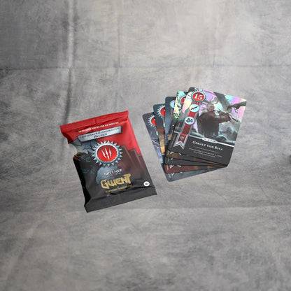 Eine versiegelte Gwent - Legendäre Balladenkarten Packung von Asmodee ruht auf einer grauen Fläche neben aufgefächerten Karten, die oberste zeigt Great Von Riva - ein idealer Fund für Fans, die seltene Foil-Karten suchen.