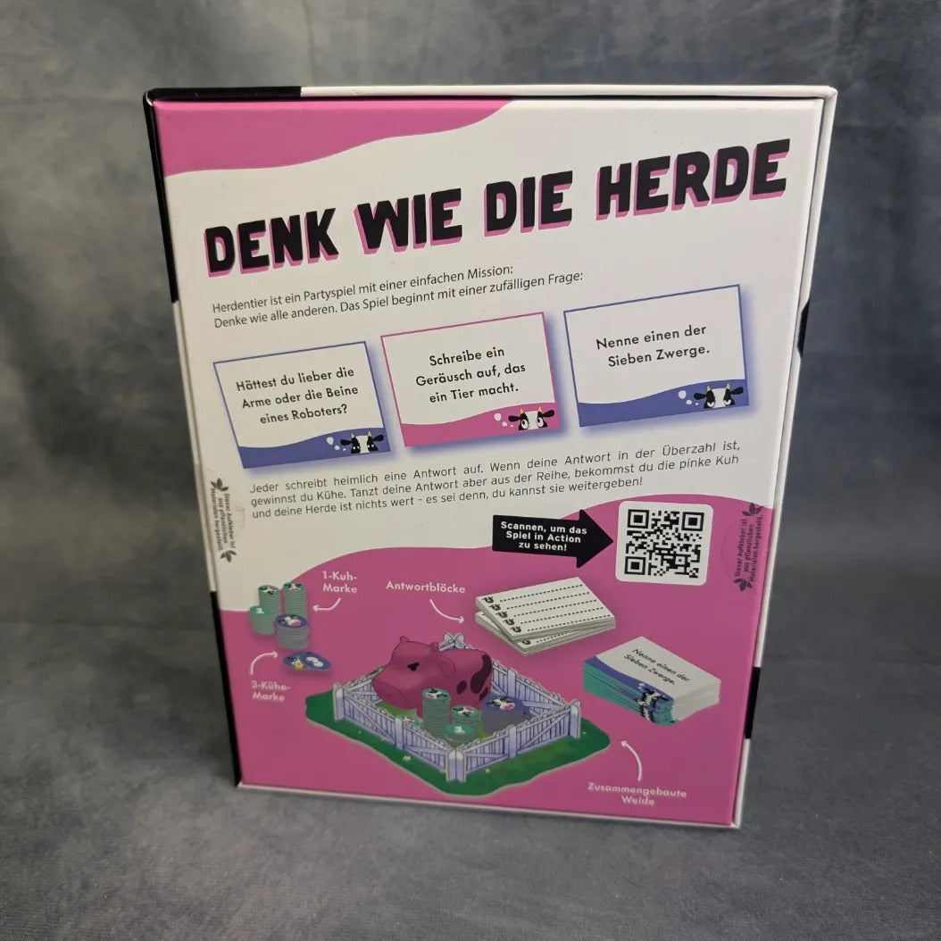 Das Bild zeigt die Rückseite einer Gesellschaftsspiel-Schachtel der Burst Spiele mit dem Titel „Herdentier“, auf der ein verspielter deutscher Text, farbenfrohe Illustrationen einer rosa Kuh und von Spielkarten, ein QR-Code sowie lebhafte lila-weiße Designelemente im Partyspiel-Stil zu sehen sind.